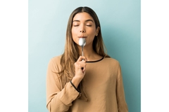 woman savoring the last bit of food on a spoon